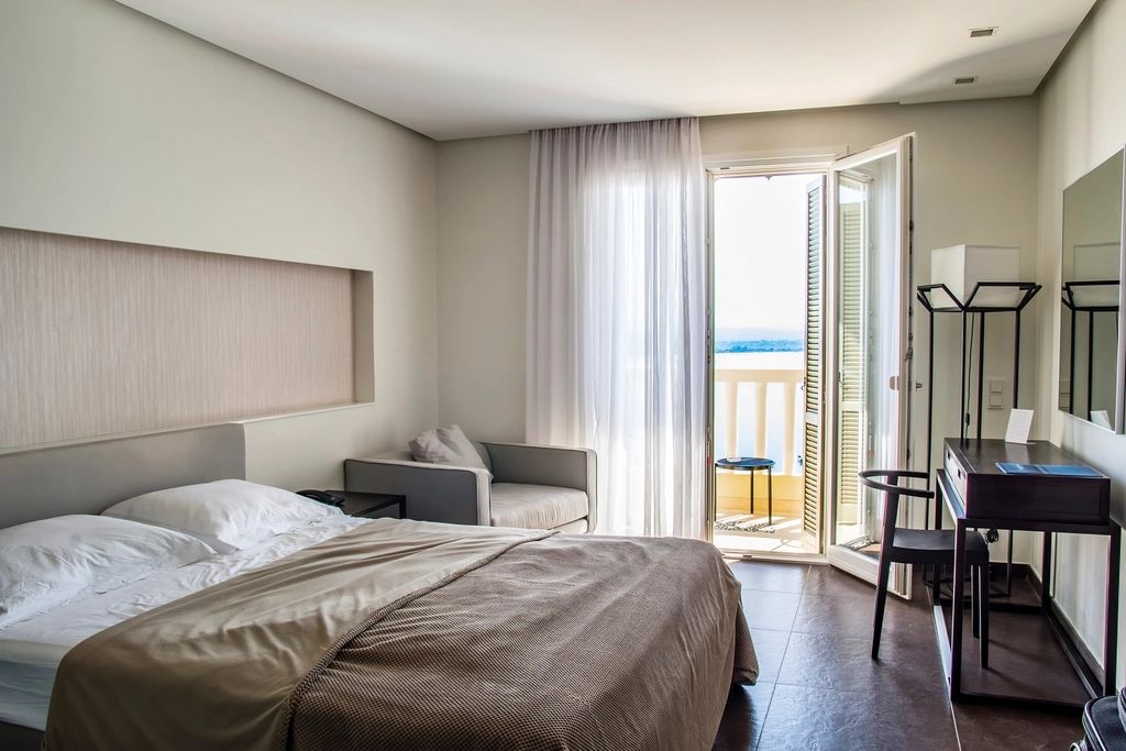 A guest room with a large bed and soft lighting